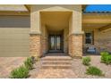 Charming front porch featuring stone pillars, brick walkway, with inviting seating, and desert landscaping at 6098 Avery Pointe St, Las Vegas, NV 89166