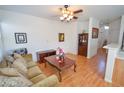 Cozy living room features wood laminate flooring and ceiling fan at 6098 Darkfeather Way, Las Vegas, NV 89139