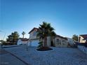 Charming two-story home featuring a two-car garage and low-maintenance desert landscaping with a mature palm tree at 6746 Shelter Ln, Las Vegas, NV 89103