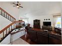 Bright living room featuring hardwood floors, a ceiling fan, and stairs that lead to the upper level at 6746 Shelter Ln, Las Vegas, NV 89103