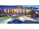 Stunning backyard pool and spa area features natural rock accents and seamless integration with the home's architecture at 69 Tapadero Ln, Las Vegas, NV 89135