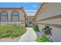 Inviting front entrance with a tiled roof, colorful flowers, and walkway leading to the front door at 6920 Haven Hollow Ave, Las Vegas, NV 89130
