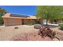 Charming single-story home featuring mature landscaping, desert rock, and solar panels on the roof at 710 Tomahawk Ct, Pahrump, NV 89060