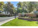Neighborhood entrance with well-maintained landscaping and mature trees creating a welcoming atmosphere at 7889 Rancho Mirage Dr, Las Vegas, NV 89113