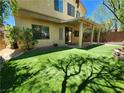 Backyard featuring manicured artificial turf and a covered patio, perfect for outdoor living at 9052 Pine Mission Ave, Las Vegas, NV 89143