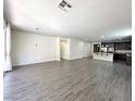 Spacious living room featuring sleek, modern wood-look flooring, neutral walls, and ample natural light at 907 Gallery Course Dr, Las Vegas, NV 89148