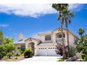 Elegant two-story home with a three-car garage, balcony, and a beautifully landscaped front yard with mature trees at 9155 Harvest Homes St, Las Vegas, NV 89123