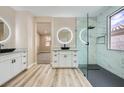 Elegant bathroom with a walk-in shower, modern vanity, round backlit mirror, and wood-look flooring at 9272 W Viking Rd, Las Vegas, NV 89147