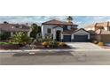 Charming stucco home boasts a red tile roof, two-car garage and low maintenance desert landscaping at 9272 W Viking Rd, Las Vegas, NV 89147