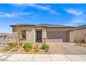 Inviting single-story home with a brick driveway, desert landscaping, and neutral color palette at 10186 Zeta Tucana St, Las Vegas, NV 89143