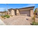 Attractive single-story house with a brick driveway, desert landscaping, and a two-car garage at 10186 Zeta Tucana St, Las Vegas, NV 89143
