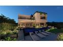 A modern home's backyard featuring a sleek pool, lounge chairs, and well-manicured landscaping at 120 Still Shores St, Henderson, NV 89011
