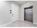 Modern hallway with sleek elevator and white entrance door, adding convenience and style to the space at 128 Los Cabos Dr # 302, Las Vegas, NV 89144