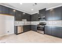 Modern kitchen with stainless steel appliances, sleek dark cabinets, and light countertops at 1801 Flycatch St, Las Vegas, NV 89138