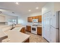 Compact kitchen featuring modern appliances, wooden cabinetry and a large sink at 2509 April Breeze Ln, Henderson, NV 89002