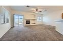 Open concept living room with a fireplace and sliding glass doors to the backyard at 2509 April Breeze Ln, Henderson, NV 89002