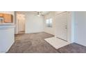 Living room with neutral walls and floors, a ceiling fan, and a front door at 2509 April Breeze Ln, Henderson, NV 89002