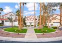 Beautifully landscaped front yard with lush greenery, a water fountain, and towering palm trees at 2608 Sun Reef Rd, Las Vegas, NV 89128
