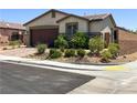 Well-maintained home with desert landscaping, a two-car garage, and a paved driveway for added curb appeal at 2772 Brinkley Manor St, Laughlin, NV 89029