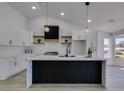 Bright, modern kitchen boasts white cabinetry, a black island, and stainless steel appliances at 2905 Legend Dr, Las Vegas, NV 89134