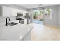 Modern kitchen featuring stainless steel appliances, white cabinets, sleek countertops, and backyard views at 3532 Mountain Park St, Las Vegas, NV 89129