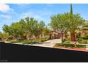 Beautiful single-story home showcasing mature trees, stone accents, and a brick driveway at 38 Pebble Dunes Ct, Las Vegas, NV 89141