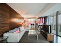 Stylish living room with a fireplace, modern furniture, dark wood accent wall, and views from the floor-to-ceiling window at 4381 W Flamingo Rd # 2902, Las Vegas, NV 89103