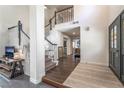 Open entryway with a staircase, featuring a decorative front door, and hardwood flooring throughout the area at 5381 Waving Sage Dr, Las Vegas, NV 89149
