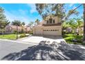 A view of a two-story house with a red tile roof and three-car garage at 5381 Waving Sage Dr, Las Vegas, NV 89149