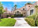 Lovely home exterior featuring manicured lawn, mature landscaping, and charming architectural details at 5381 Waving Sage Dr, Las Vegas, NV 89149