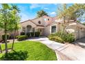 Beautifully landscaped front yard with lush green grass leading to a charming two-story home at 5381 Waving Sage Dr, Las Vegas, NV 89149