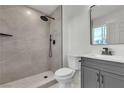 Modern bathroom with walk-in shower, dark fixtures, gray vanity at 5617 Reiter Ave, Las Vegas, NV 89108