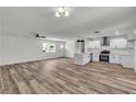Open-concept living room featuring modern kitchen, fan and fireplace at 5617 Reiter Ave, Las Vegas, NV 89108