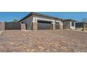 Wide, multi-toned brick driveway leads to a three-car garage, enhancing the home's curb appeal at 5851 Slate Rock Ct, Las Vegas, NV 89149