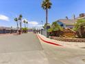 Community entrance with stone sign, palm trees, well-maintained landscaping, and security gates at 5861 Medallion Dr # 202, Las Vegas, NV 89122