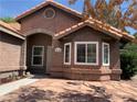 Charming single-story home with red tile roof and inviting front entrance and desert landscaping at 6704 Lost River Ct, Las Vegas, NV 89108