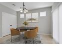 Staged dining area with a modern table and chairs, stylish light fixture, and neutral décor at 7263 Pepperbox Ave, Las Vegas, NV 89179