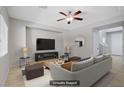Staged living room with neutral decor, tiled flooring, ceiling fan, and large flat screen television at 7263 Pepperbox Ave, Las Vegas, NV 89179
