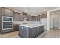 Well-equipped kitchen featuring stainless steel appliances, gray cabinets, a large island, and a quartz countertop at 765 Cloud Creek St, Henderson, NV 89011