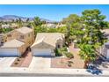Aerial view of single-story house with desert landscaping, two car garage, and desert mountain views at 8324 Tide Pool Dr, Las Vegas, NV 89128