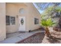 Inviting entryway with a decorative door, tiled walkway, and desert landscaping at 8324 Tide Pool Dr, Las Vegas, NV 89128