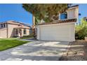 A view of the front of a home with a red tile roof and spacious driveway at 8809 Beach Front Dr, Las Vegas, NV 89117