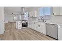 Bright open kitchen boasts stainless steel appliances, quartz countertops, stylish cabinetry and durable wood-look floors at 8944 W Rochelle Ave, Las Vegas, NV 89147