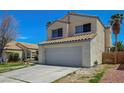 Side view of the property with a tile roof and spacious two-car garage, complemented by desert landscaping at 901 Carnival Ave, Las Vegas, NV 89123