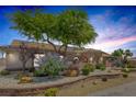 Landscaped exterior with decorative rock, mature trees, and brick accents provide curb appeal at 9015 S Tenaya Way, Las Vegas, NV 89113