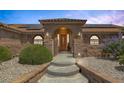 Inviting front entrance with concrete steps, rock details, arched entry, and a secure gated entry at 9015 S Tenaya Way, Las Vegas, NV 89113