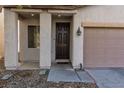 Inviting front entrance with a dark wood door and a covered porch area at 908 Shining Rose Pl, Henderson, NV 89052