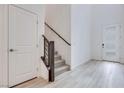Bright entryway featuring wood-look flooring, a staircase, and a modern frosted-glass front door at 11904 Glide Reflection Ave, Las Vegas, NV 89138