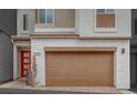 Close-up of a two-car garage, modern architecture, and a red front door at 11904 Glide Reflection Ave, Las Vegas, NV 89138