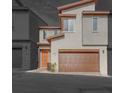 Modern townhomes with stone accents, brown garages, and eye-catching orange front doors at 11922 Glide Reflection Ave, Las Vegas, NV 89138